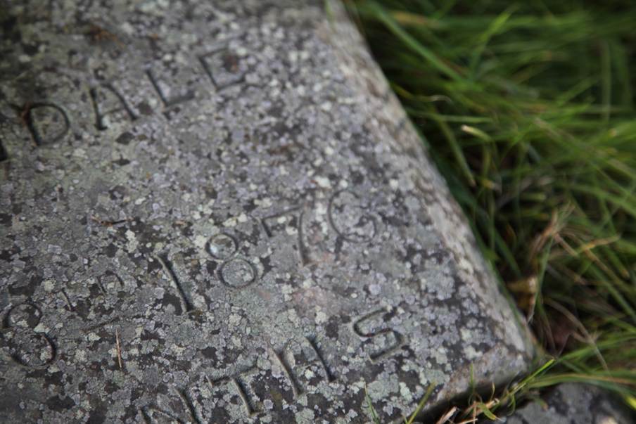 A stone with engraved text on it

Description automatically generated